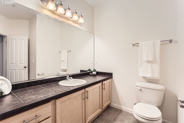 bathroom featuring toilet, tile patterned flooring, baseboards, and vanity