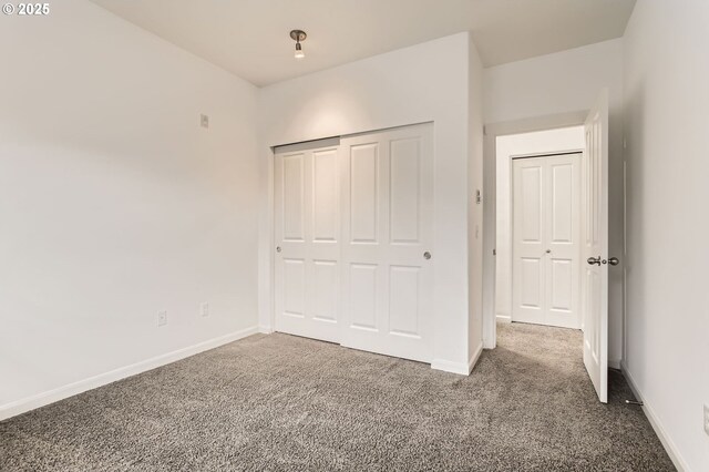 unfurnished bedroom with a closet, baseboards, and carpet floors