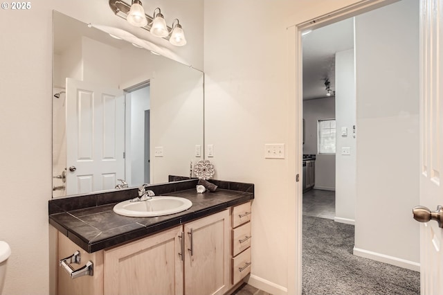 bathroom featuring toilet, vanity, and baseboards