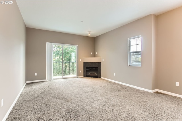 unfurnished living room with carpet floors, a wealth of natural light, and a fireplace