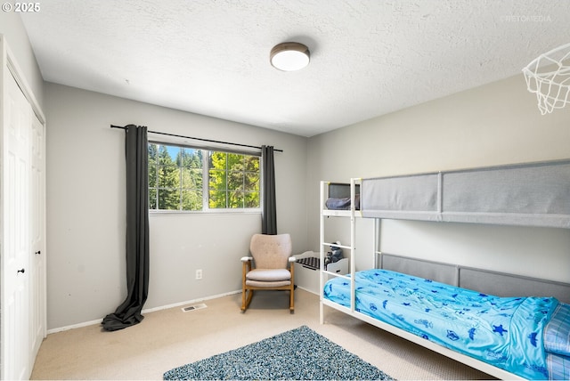 6750 SW Parkwest Ln, Portland, OR 97225 - carpeted bedroom with a textured ceiling, baseboards, and a closet