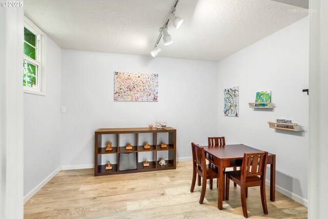 6750 SW Parkwest Ln, Portland, OR 97225 - dining area with wood finished floors, baseboards, a textured ceiling, and track lighting