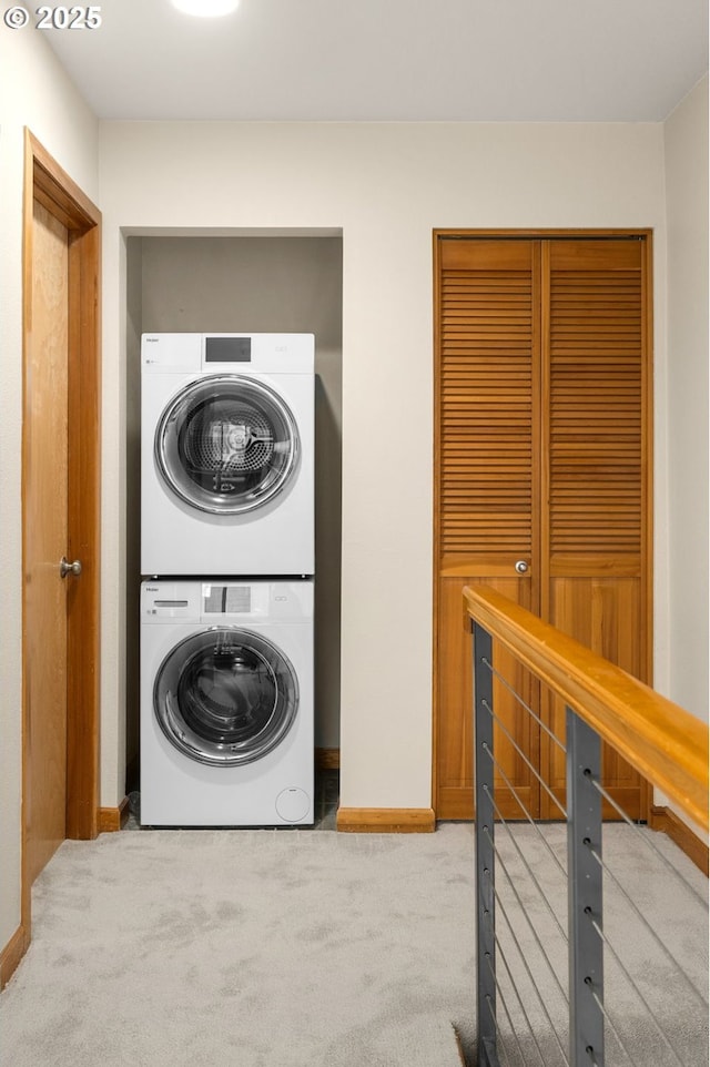 clothes washing area featuring stacked washer / dryer and light colored carpet