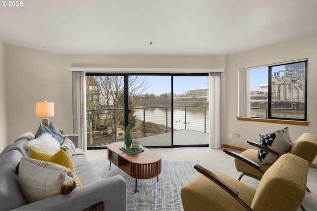 living room featuring light colored carpet and a water view