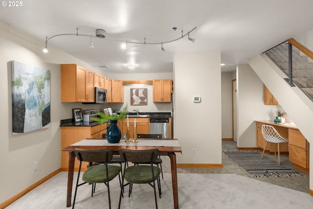 kitchen with stainless steel appliances, rail lighting, sink, and light brown cabinets