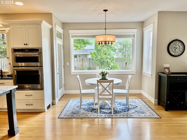 dining area with light wood-style flooring, baseboards, a chandelier, and recessed lighting