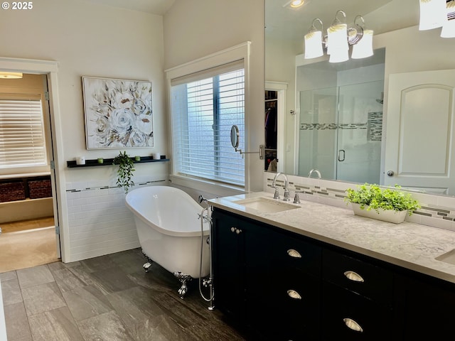 bathroom featuring a shower stall, double vanity, and a freestanding tub
