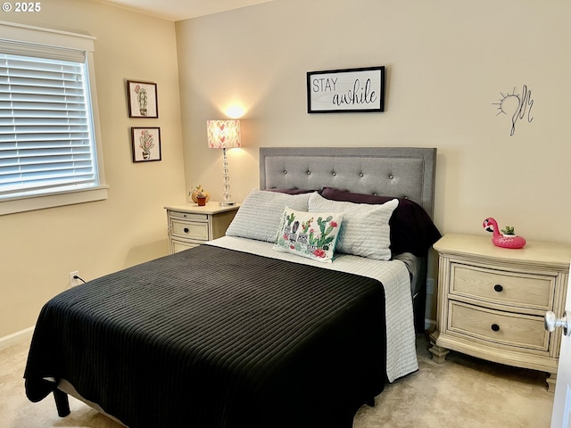 bedroom featuring light carpet and baseboards