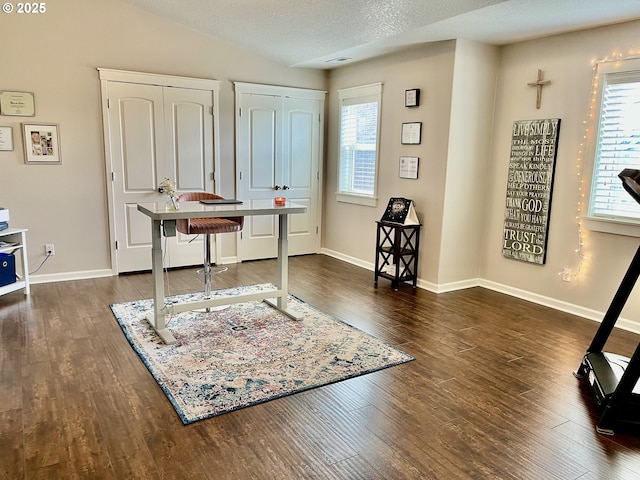 entrance foyer with plenty of natural light, wood finished floors, baseboards, vaulted ceiling, and a textured ceiling