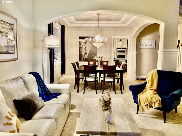 dining space featuring arched walkways, a chandelier, light colored carpet, and a tray ceiling