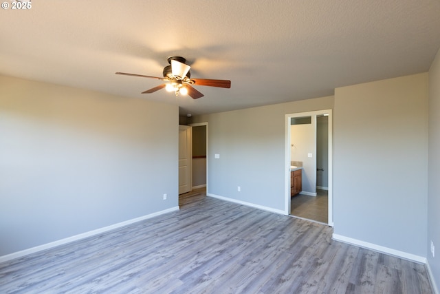 empty room with a ceiling fan, baseboards, and wood finished floors