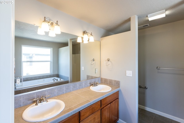 bathroom featuring tile patterned floors, double vanity, and a bathtub