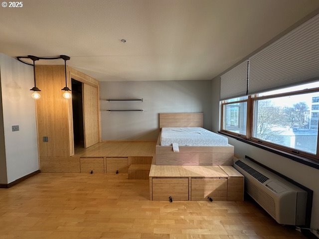 1134 SW Jefferson St Unit 503, Portland, OR 97201 - bedroom with wood finished floors and a wall mounted air conditioner