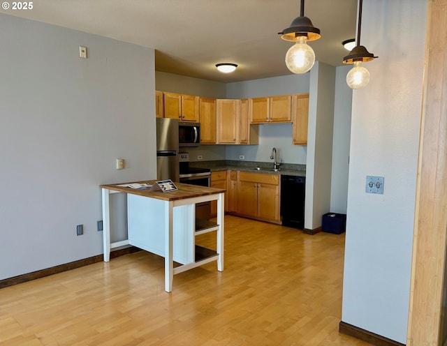1134 SW Jefferson St Unit 503, Portland, OR 97201 - kitchen with a sink, appliances with stainless steel finishes, light wood-style flooring, baseboards, and dark countertops