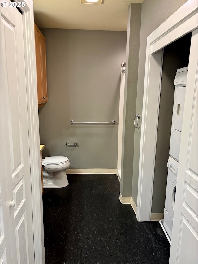 1134 SW Jefferson St Unit 503, Portland, OR 97201 - bathroom featuring stacked washing machine and dryer, toilet, baseboards, and vanity