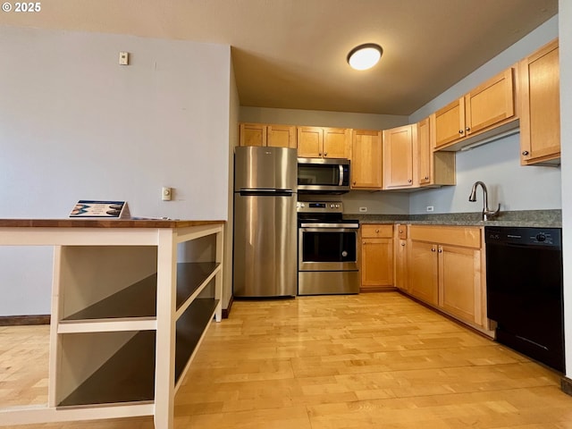1134 SW Jefferson St Unit 503, Portland, OR 97201 - kitchen featuring appliances with stainless steel finishes, dark countertops, light wood-style floors, light brown cabinets, and a sink