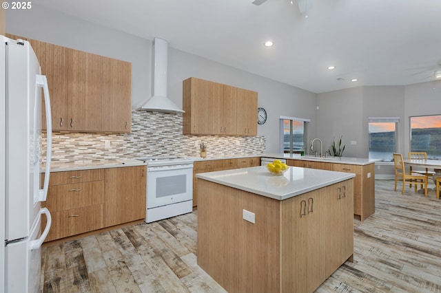 kitchen with extractor fan, a peninsula, white appliances, a sink, and a ceiling fan