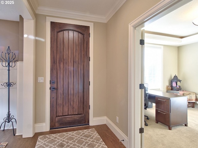 entryway featuring baseboards, ornamental molding, and wood finished floors