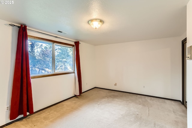 unfurnished room featuring baseboards, visible vents, and light colored carpet