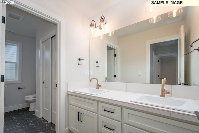 bathroom with toilet, tile patterned flooring, and vanity