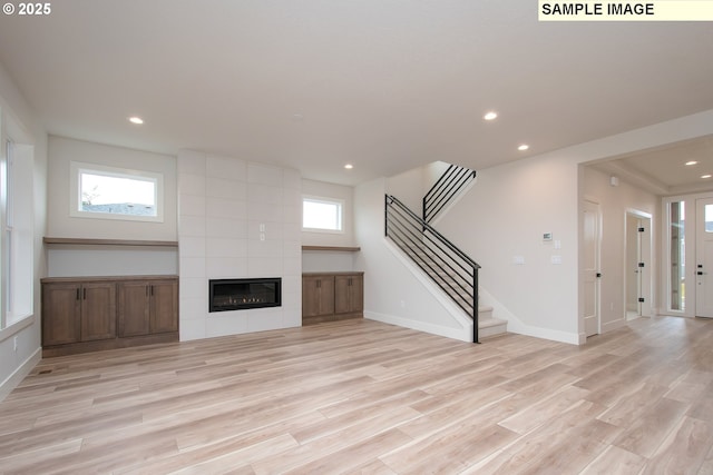 unfurnished living room with light wood-type flooring and a fireplace