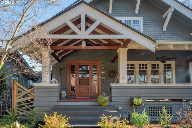 view of exterior entry featuring a porch and a ceiling fan