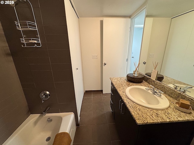 bathroom featuring tile patterned floors, baseboards, shower / bathtub combination, and vanity