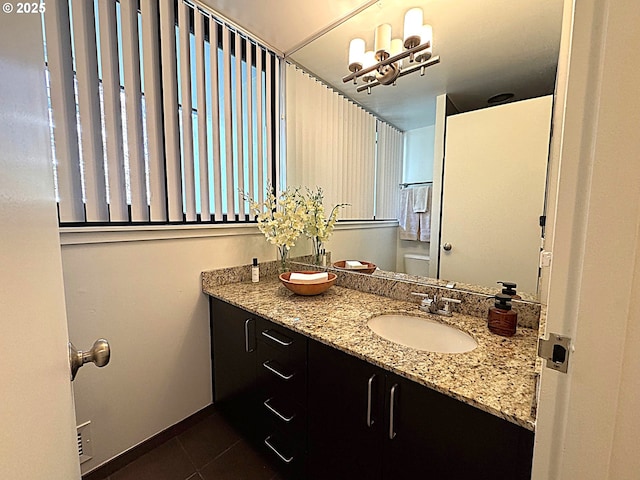 bathroom with vanity, toilet, baseboards, and tile patterned flooring