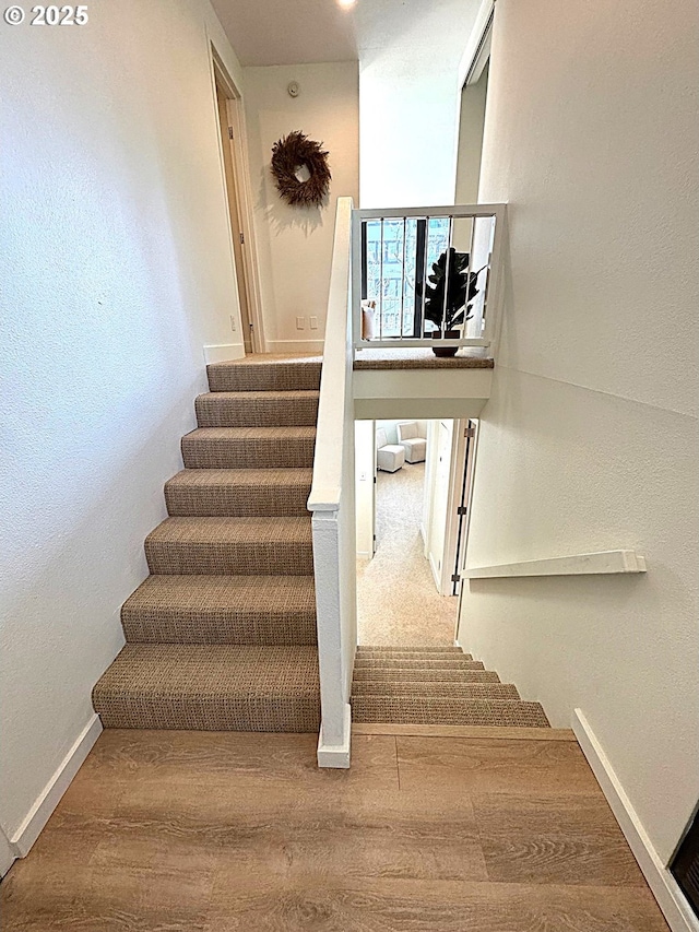 stairs featuring baseboards and wood finished floors