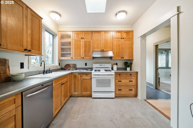 kitchen featuring white gas stove, under cabinet range hood, dishwasher, a skylight, and a sink