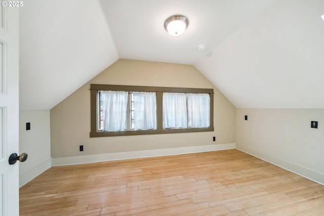 additional living space featuring lofted ceiling, wood finished floors, and baseboards