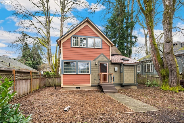 view of front facade with entry steps, metal roof, a fenced backyard, and crawl space