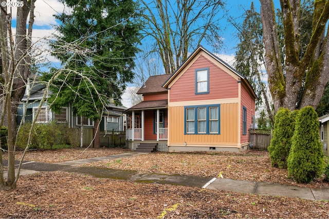 view of front of property with crawl space, roof with shingles, a porch, and fence