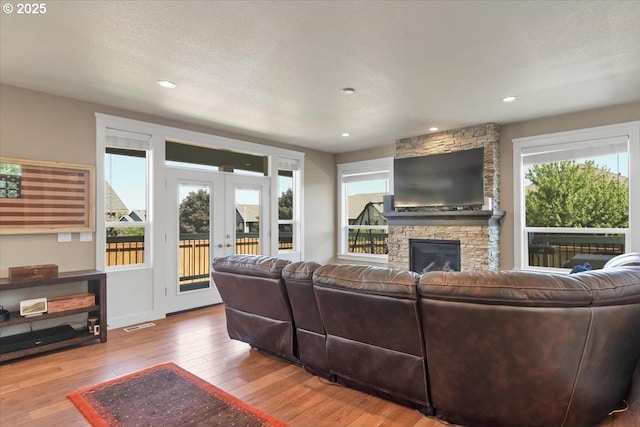 2871 Wing Tip Ave, Salem, OR 97304 - living area with hardwood / wood-style floors, a stone fireplace, french doors, and recessed lighting