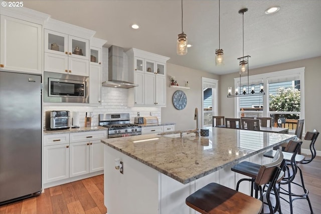 2871 Wing Tip Ave, Salem, OR 97304 - kitchen featuring stainless steel appliances, wall chimney range hood, light wood-style flooring, plenty of natural light, and recessed lighting