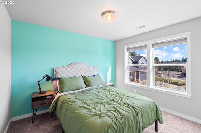 carpeted bedroom with visible vents and baseboards