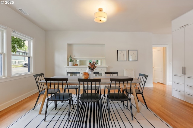 dining room featuring light wood finished floors and baseboards