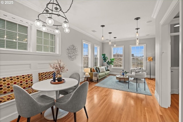 dining room with ornamental molding and light wood-type flooring