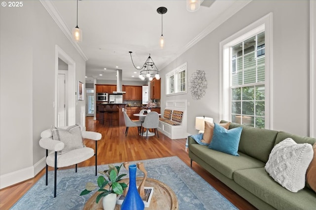 living room with ornamental molding, light hardwood / wood-style floors, and a notable chandelier