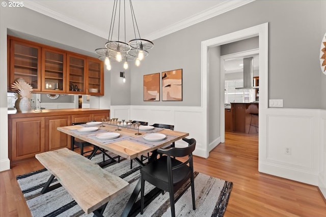 dining room featuring crown molding, a chandelier, and light hardwood / wood-style flooring