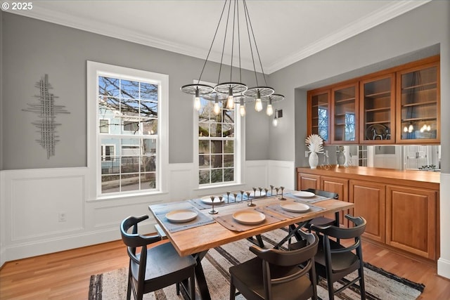 dining area featuring crown molding and light wood-type flooring