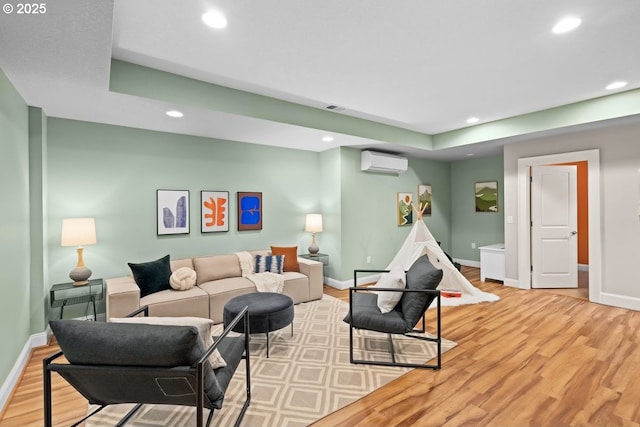 living room featuring hardwood / wood-style floors and a wall unit AC