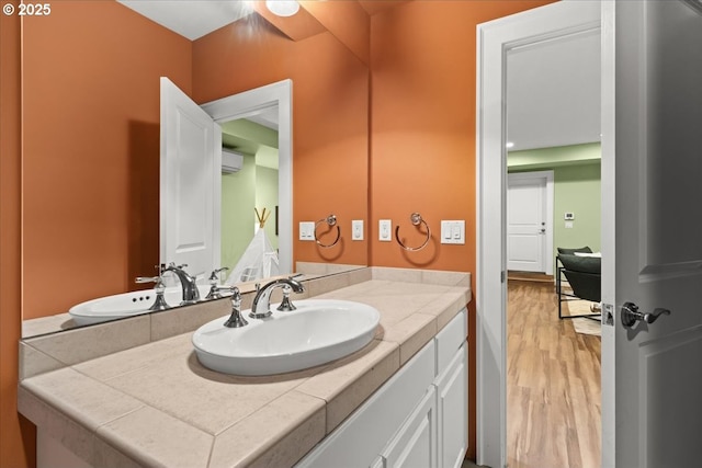 bathroom with vanity, hardwood / wood-style flooring, and a wall mounted AC