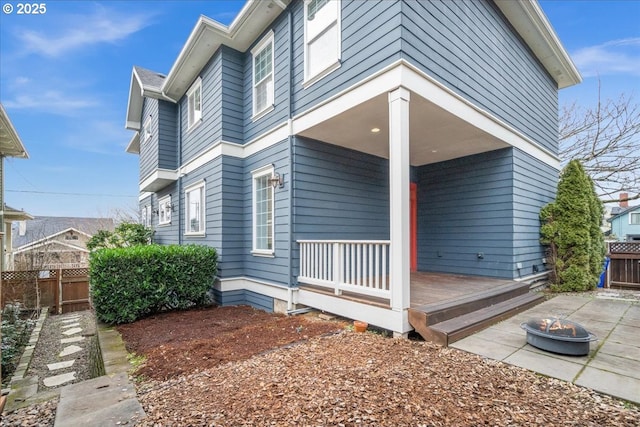 exterior space with a wooden deck and an outdoor fire pit