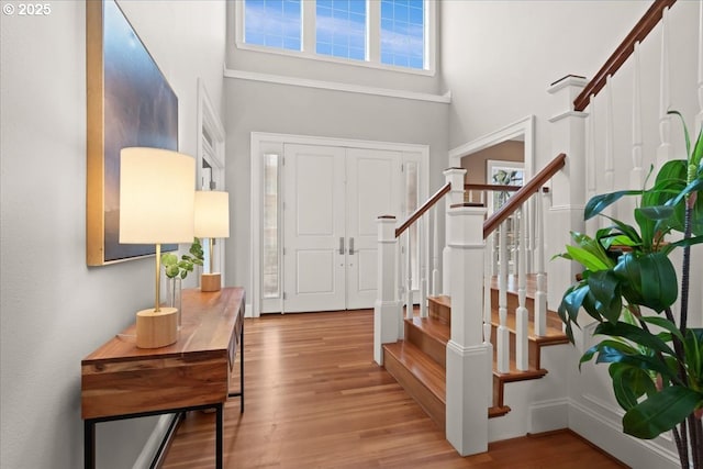 entrance foyer featuring a towering ceiling and light hardwood / wood-style floors