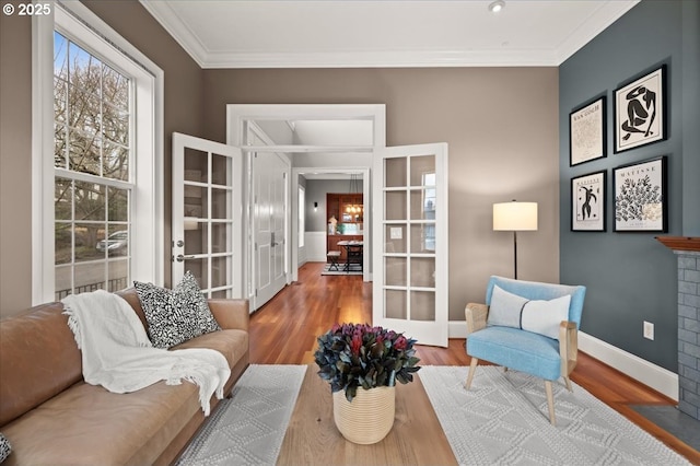 living area featuring crown molding, french doors, and hardwood / wood-style flooring