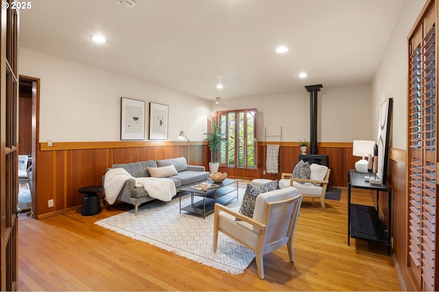 2112 Agate St, Eugene, OR 97403 - living area with a wainscoted wall, a wood stove, light wood-style floors, wooden walls, and recessed lighting