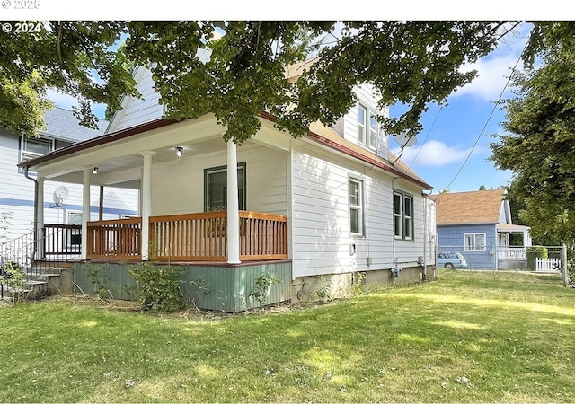 view of property exterior with a yard and covered porch