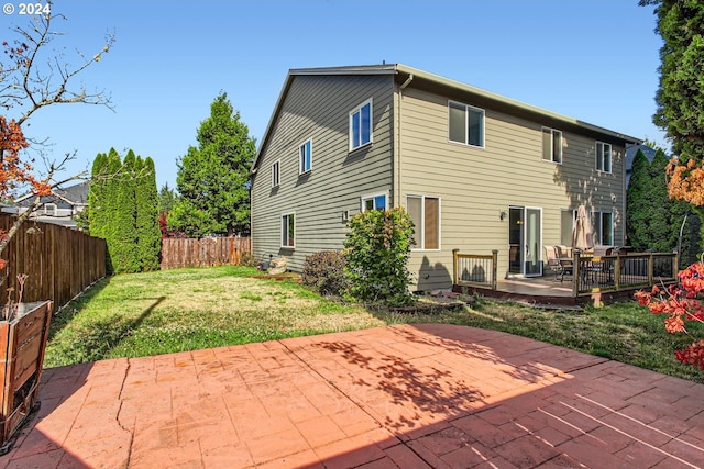 back of property with a patio and a yard