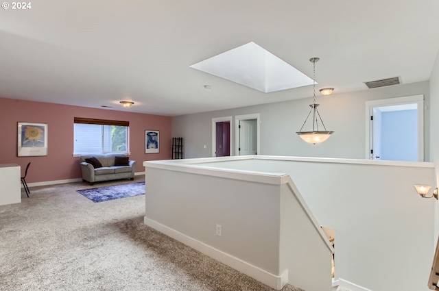 hall featuring a skylight and carpet